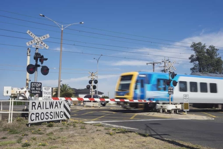 Train crosses a street during the day