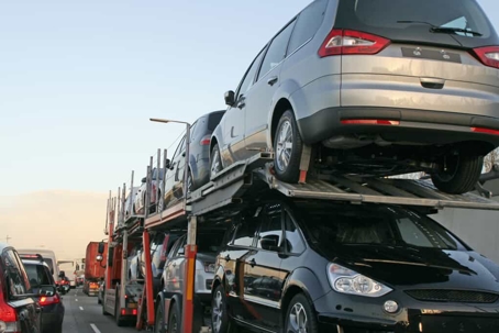 Car carrier vehicle in stopped traffic on a busy highway