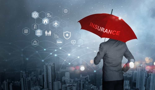 Businessman holds a red umbrella with the word "insurance" written on it in a concept photo