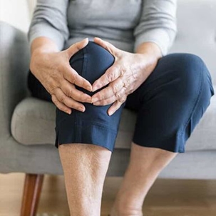 Woman holds her knee in pain after suffering an injury