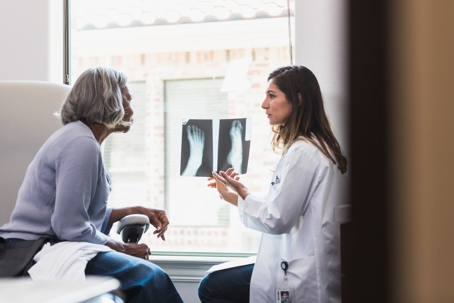 Senior woman patient speaks with doctor about injury