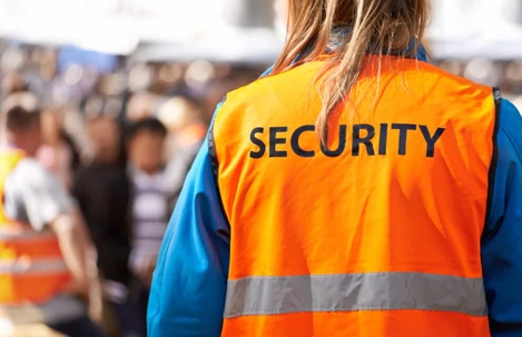 Woman wearing an orange security vest at an event