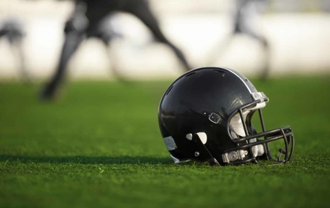 black football helmet on football field
