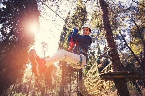 Young girl zip-lining in the woods