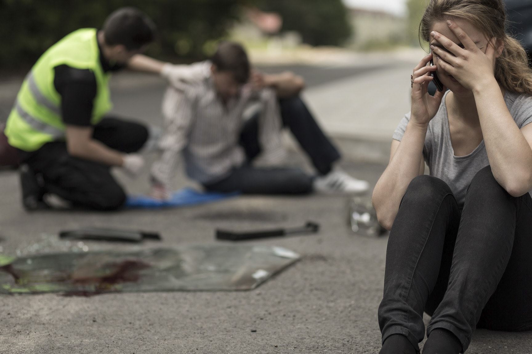 Woman sitting on the floor on the phone with hand over face