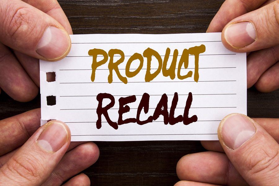 Hands holding a paper that says Product Recall