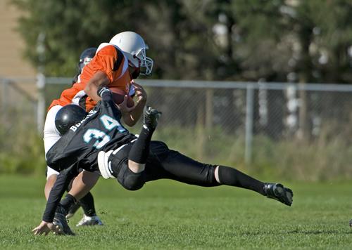 Football player tackling another player